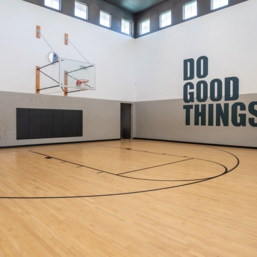  indoor basketball court with inspirational quote on wall that says "Do Good Things"
